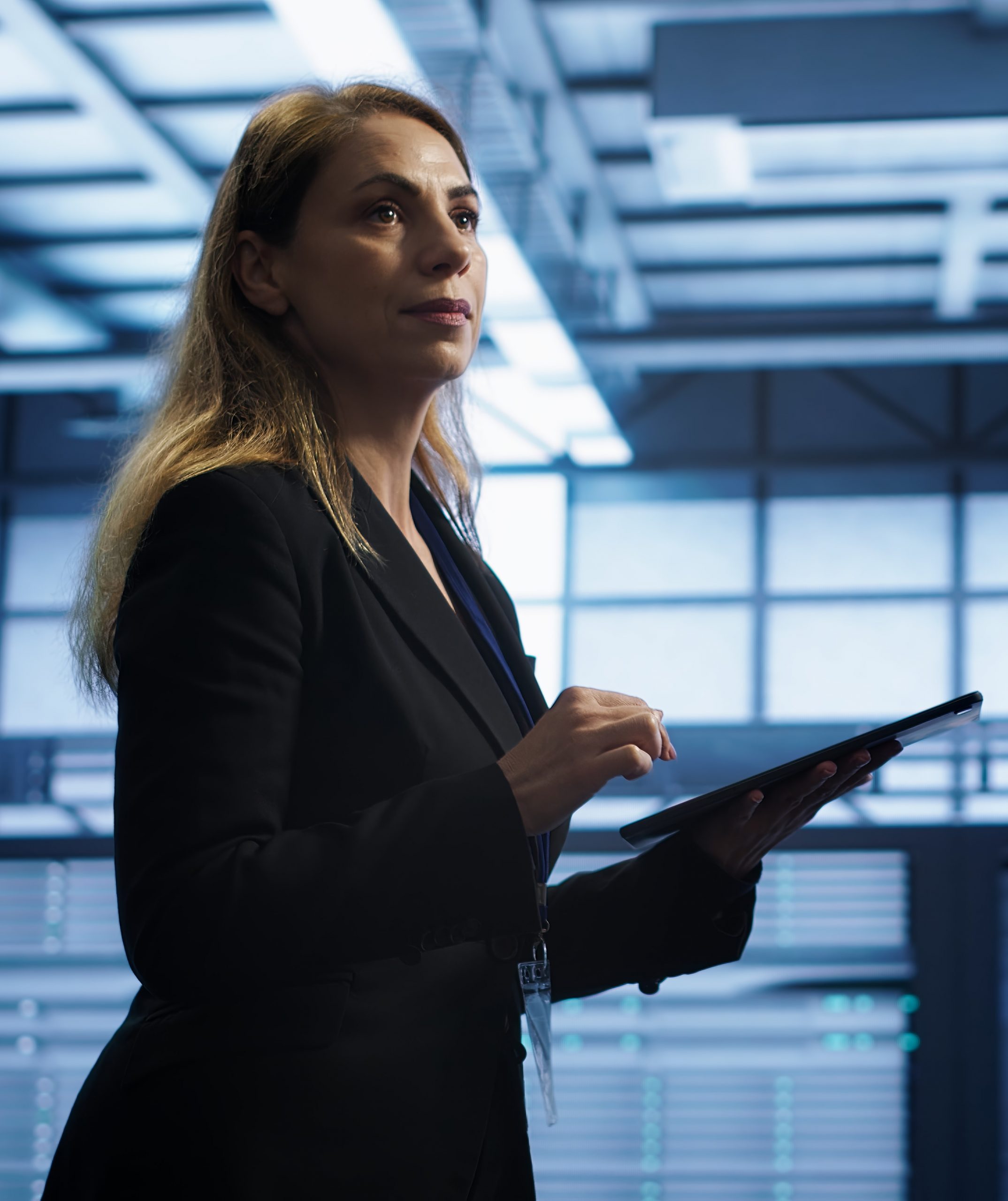 Mujer en un centro de datos asegurándose de que las plataformas funcionen de manera óptima